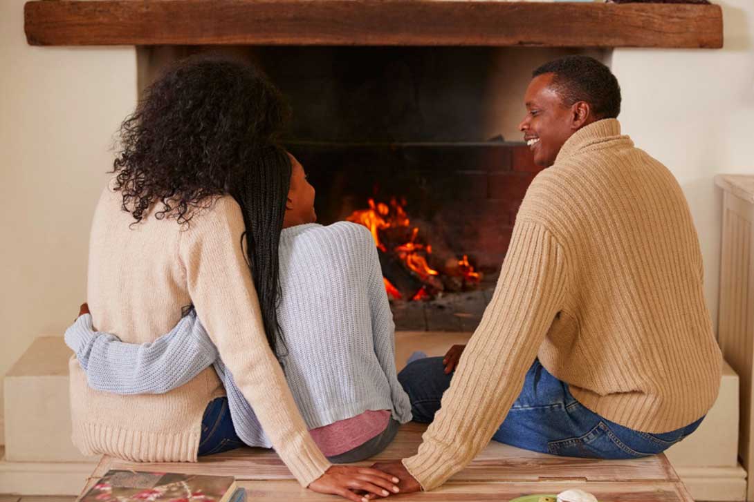 Parents sitting with daughter next to fireplace