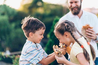 father and kids eating burgers